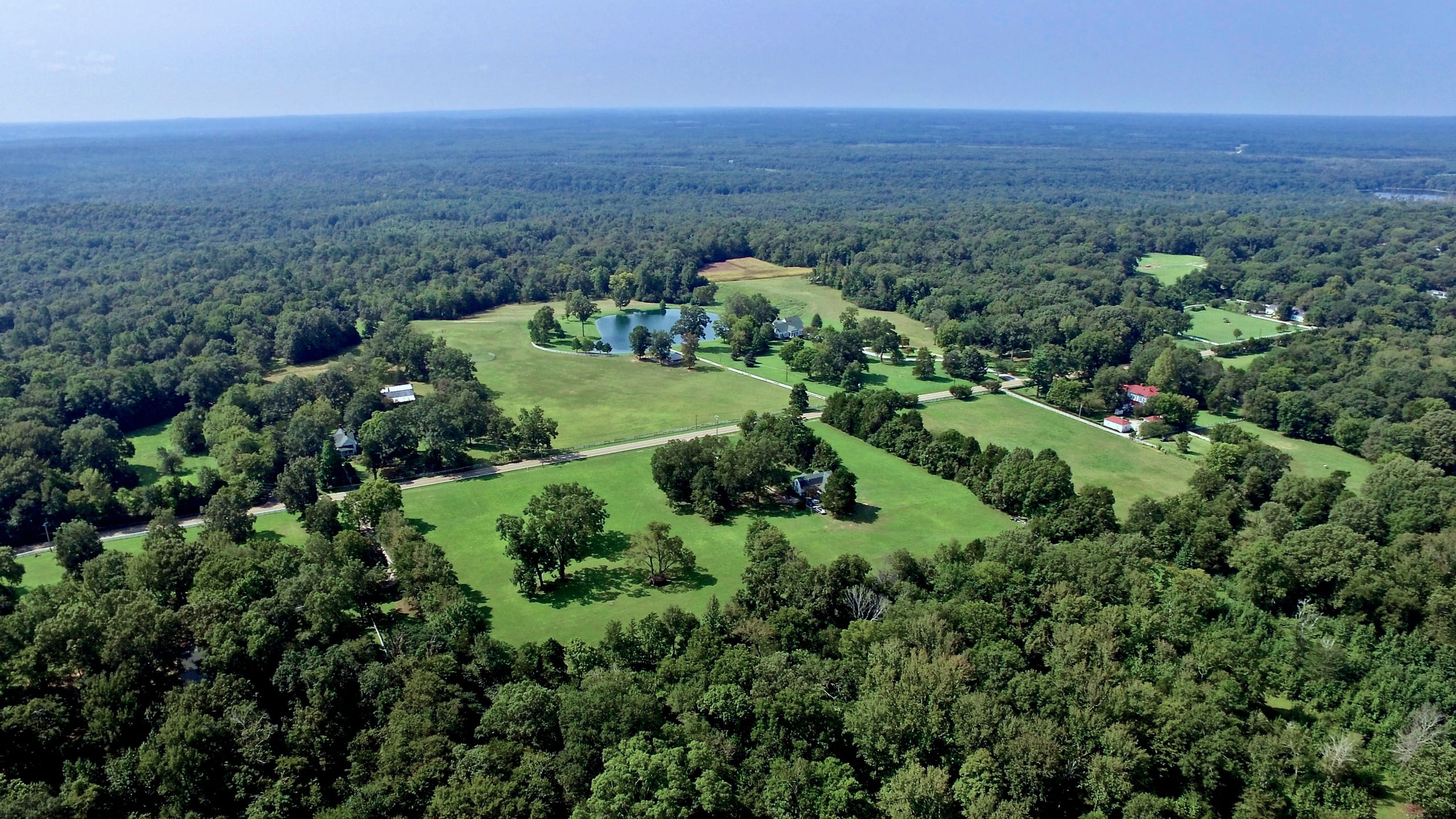 Aerial of a rural property with green trees and green fields