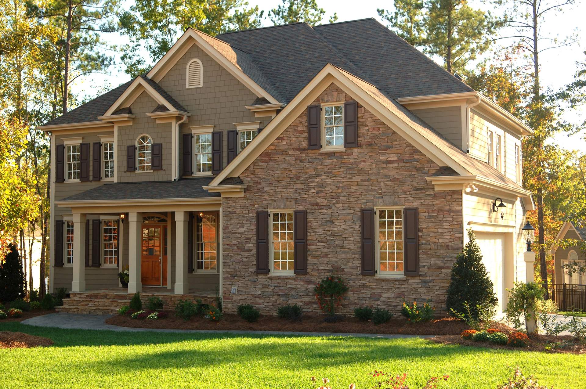 traditional home exterior of residential house, showcasing a traditional house front in a suburban home setting. Features include windows, a garage, a front yard, an entrance door, and a porch.