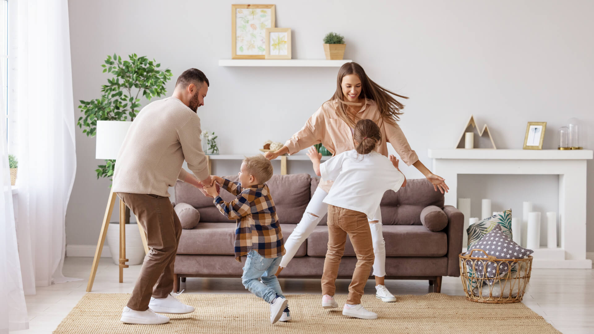 happy family mother father and kids daughter and son dancing and having fun at home
