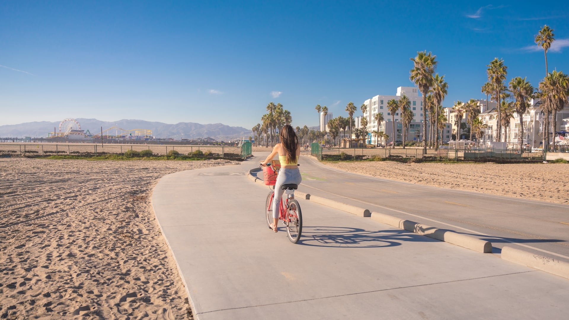 Attractive,Young,Woman,Riding,Bike,Near,Beach,With,Palm,Trees,