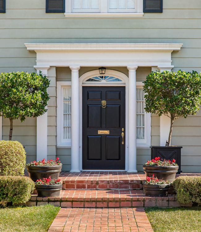 Front door of classic home with landscaped front yard and brick path(1)