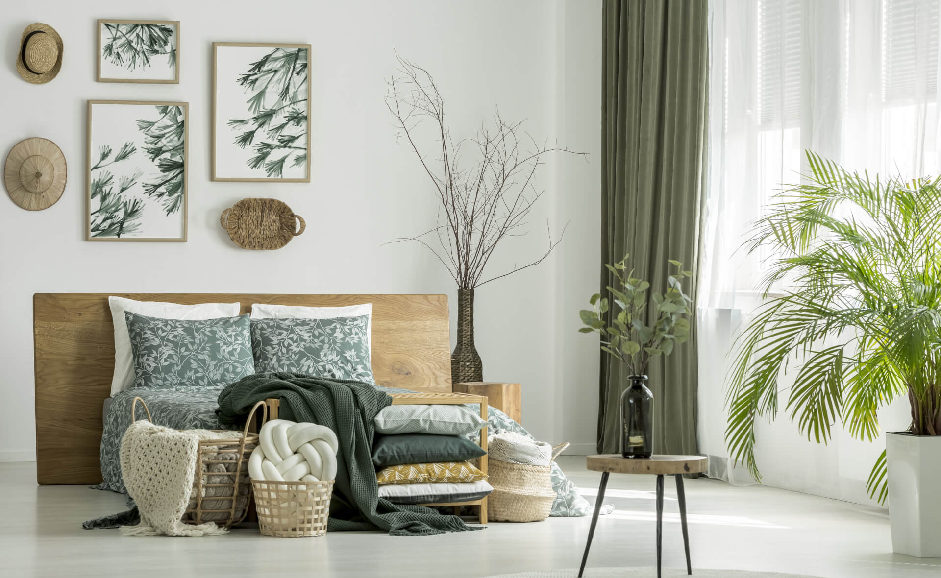 green, white bedroom with paintings