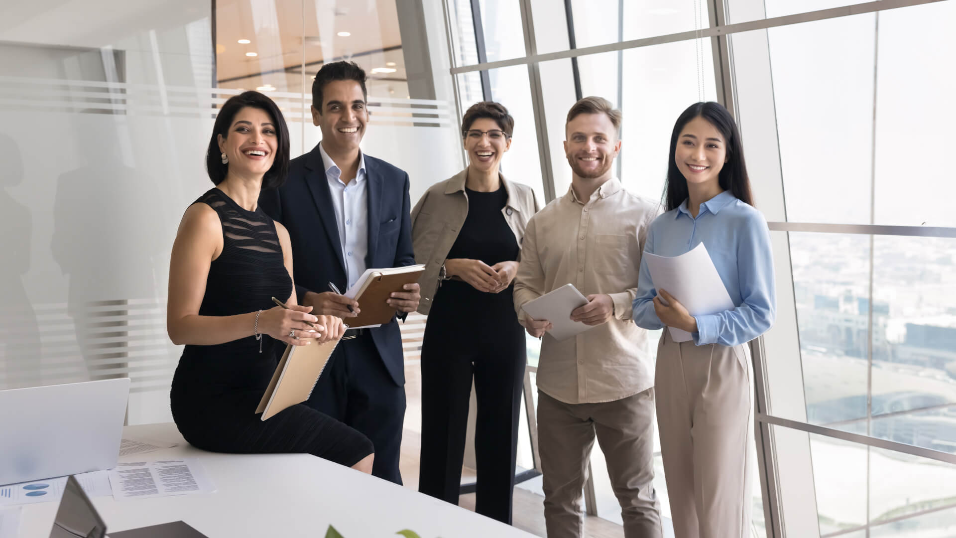 Multiethnic team of happy corporate coworkers standing in office