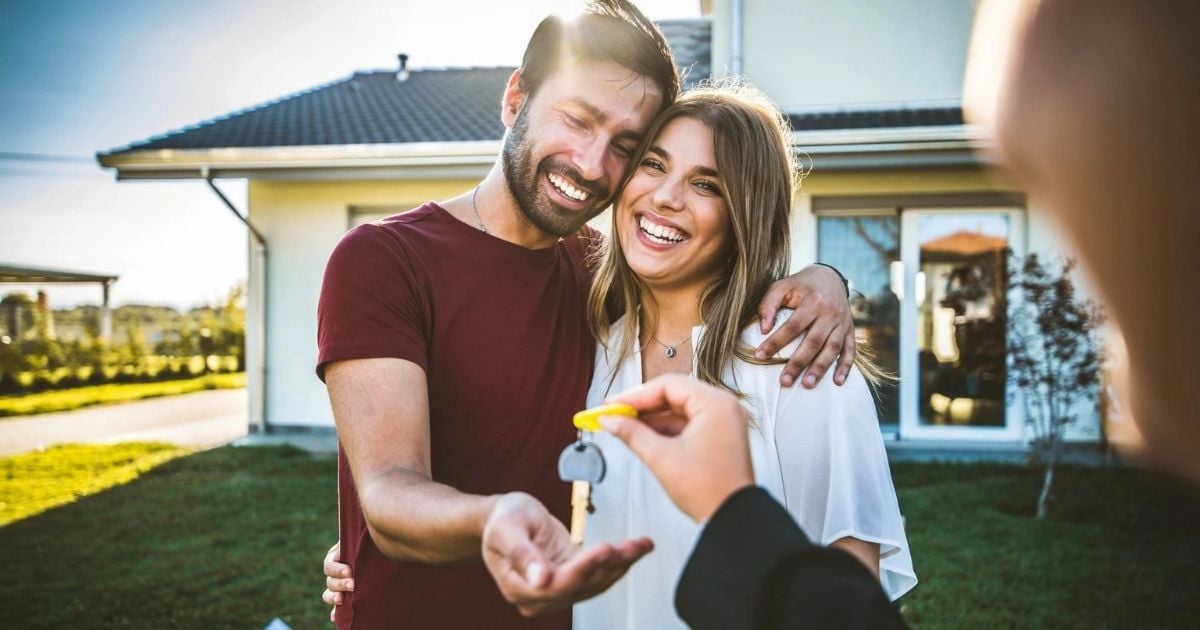 Happy-millennial-couple-receiving-keys-from-realtor