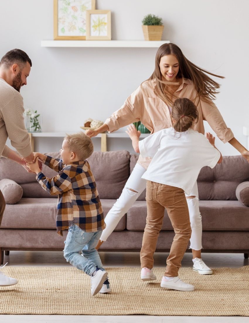 happy family mother father and kids daughter and son dancing and having fun at home verticalr