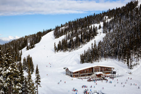 Aerial View of a big Cabin on a Ski Resort during a vibrant winter day. Taken on Blackcomb