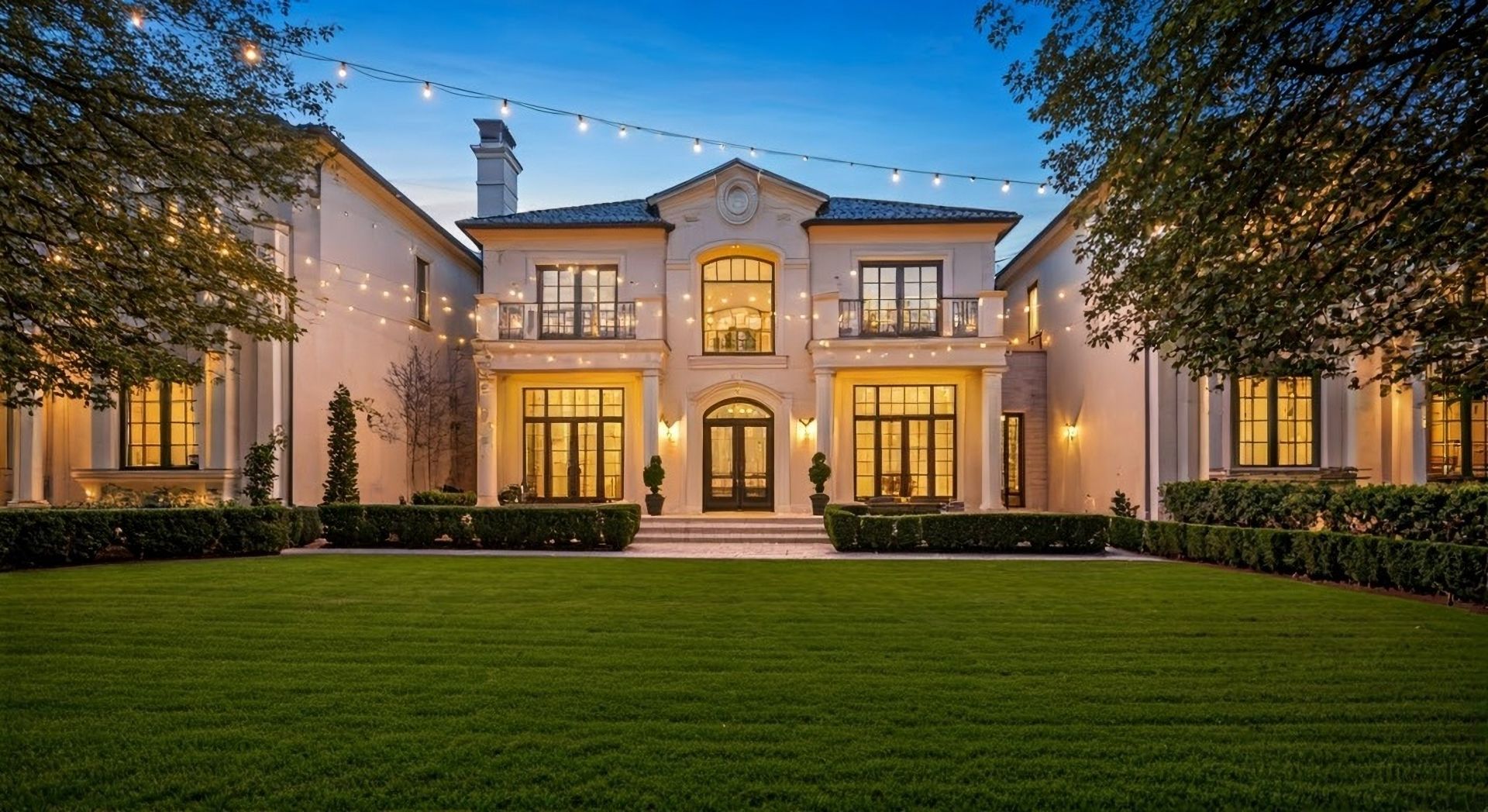 Outdoor photo of 豪华双层房子，前庭带大草地，欧式风格，傍晚时分，悬挂灯串