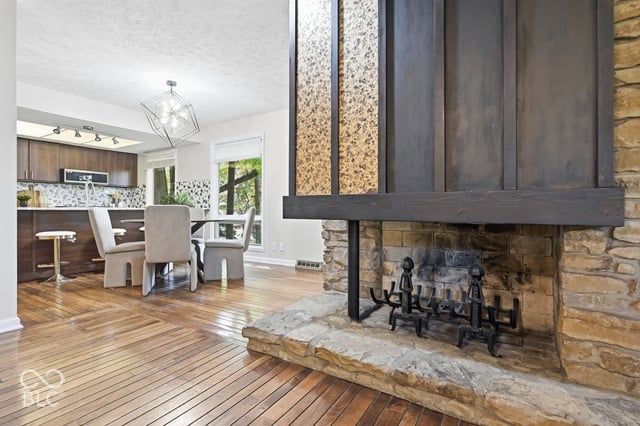 See-through stone fireplace between the living and dining rooms of the Woods House