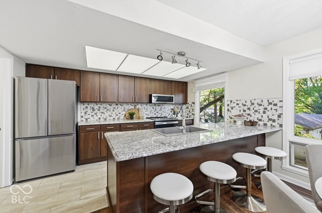 Updated kitchen with granite counters and a breakfast bar in the Woods House