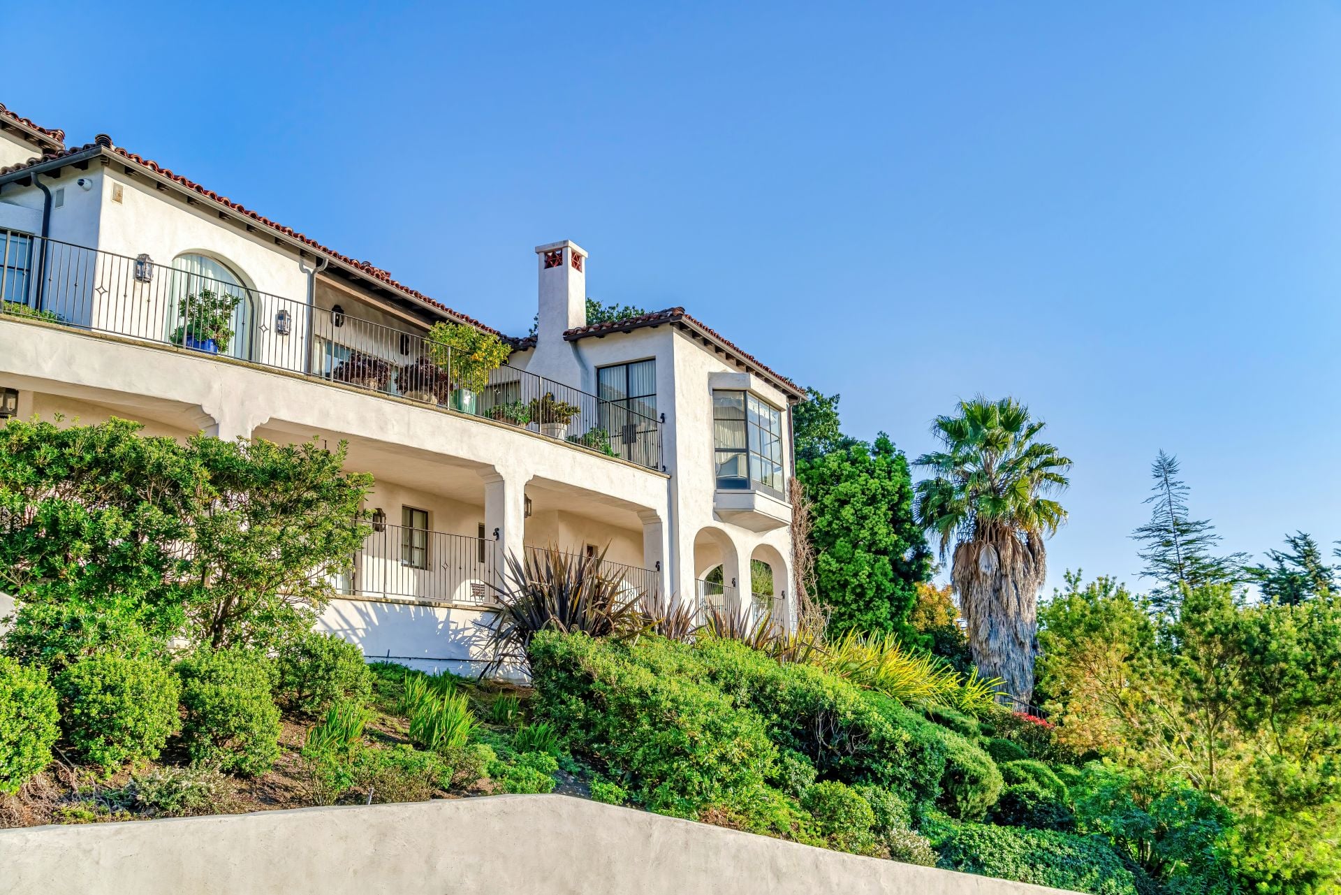 Home with balcony porch and bay window amidst foliage in San Diego California