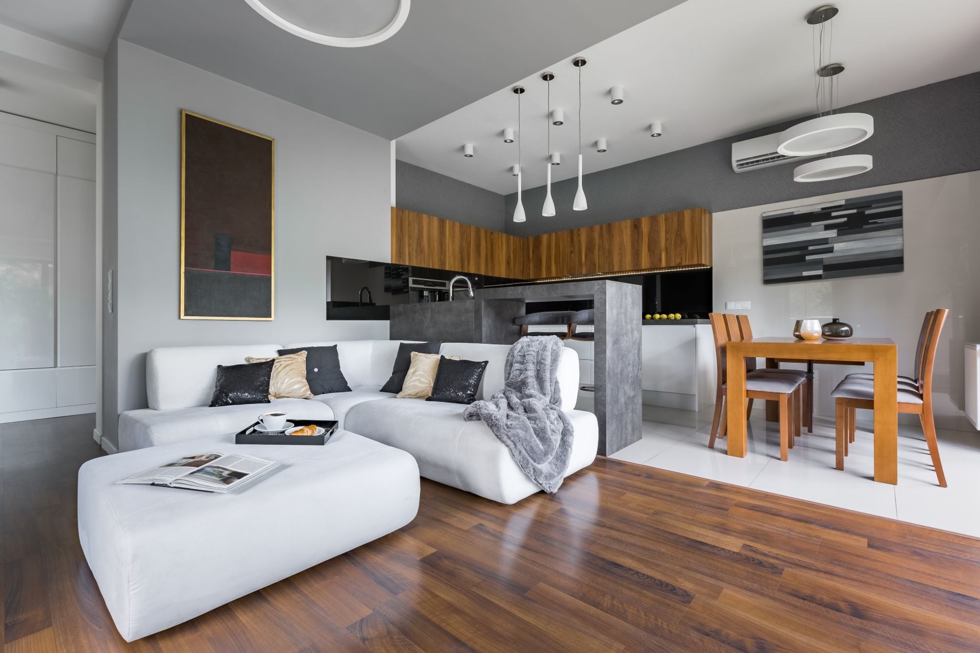 Elegant apartment with kitchen with dining area open to living room with big white corner sofa