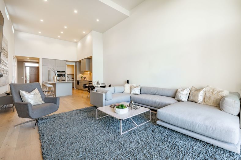 Living room interior of a waterfront condo facing the pacific ocean with floor to ceiling windows showing the view of the pacific northwest