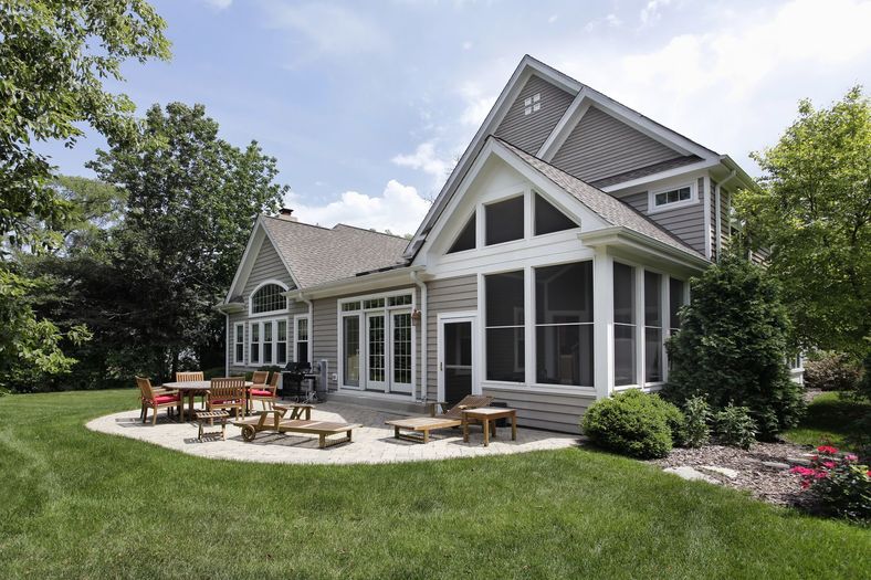 Rear view of luxury home with brick patio (1)