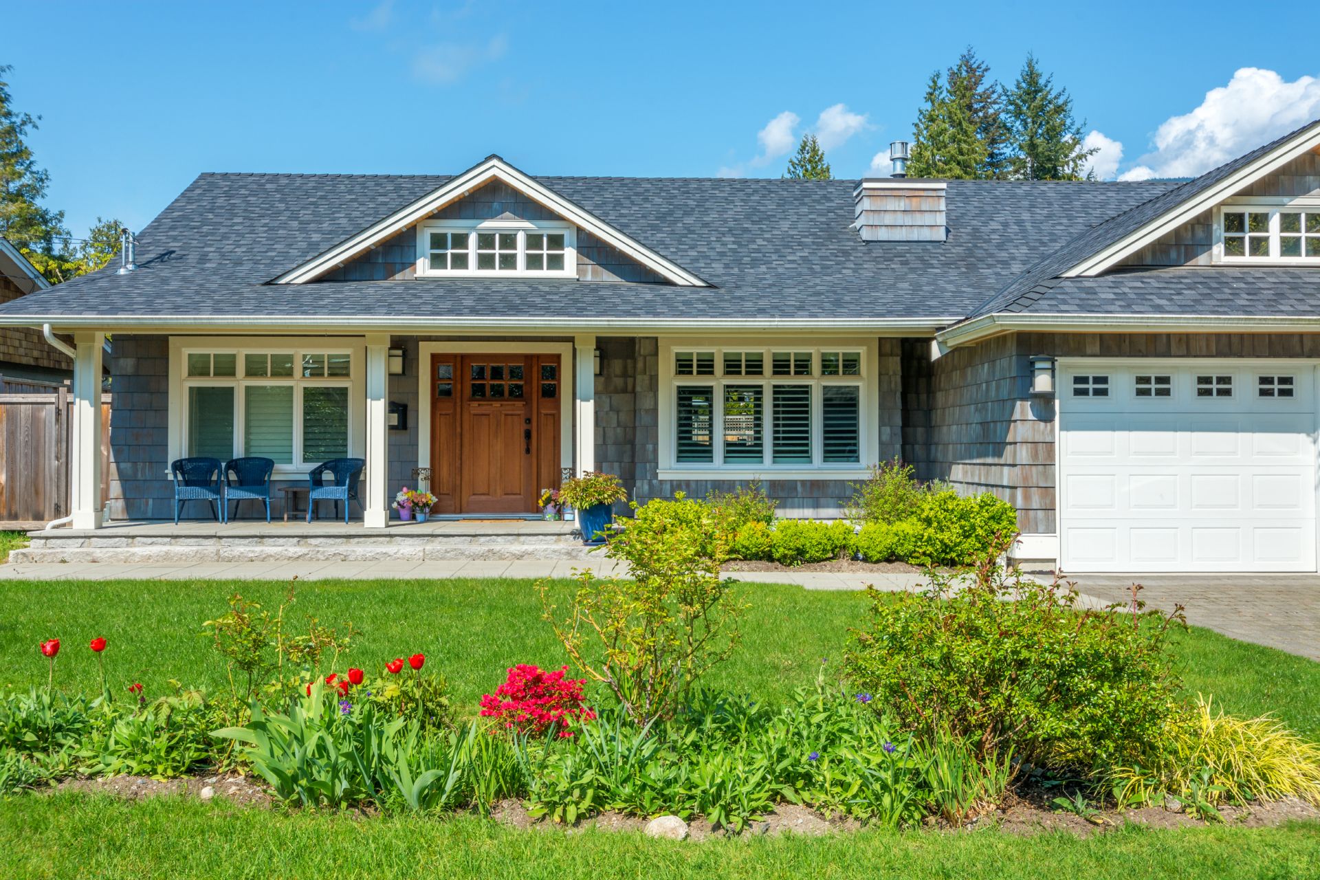 Cozy house with beautiful landscaping on a sunny day. Home exterior.