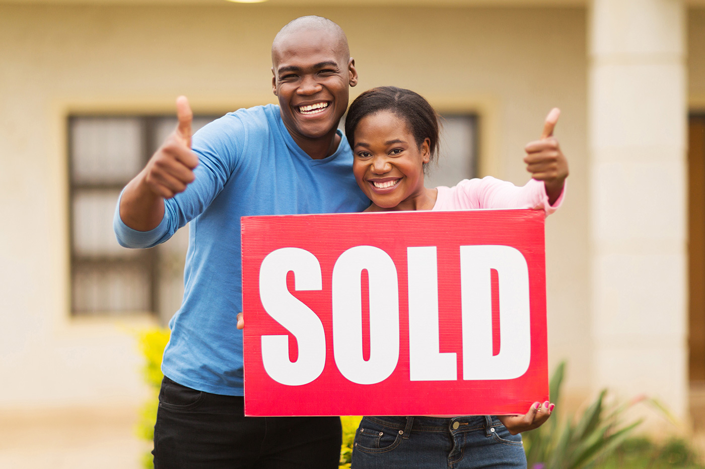 Happy-Couple-Holding-a-Sold-Sign-1400px