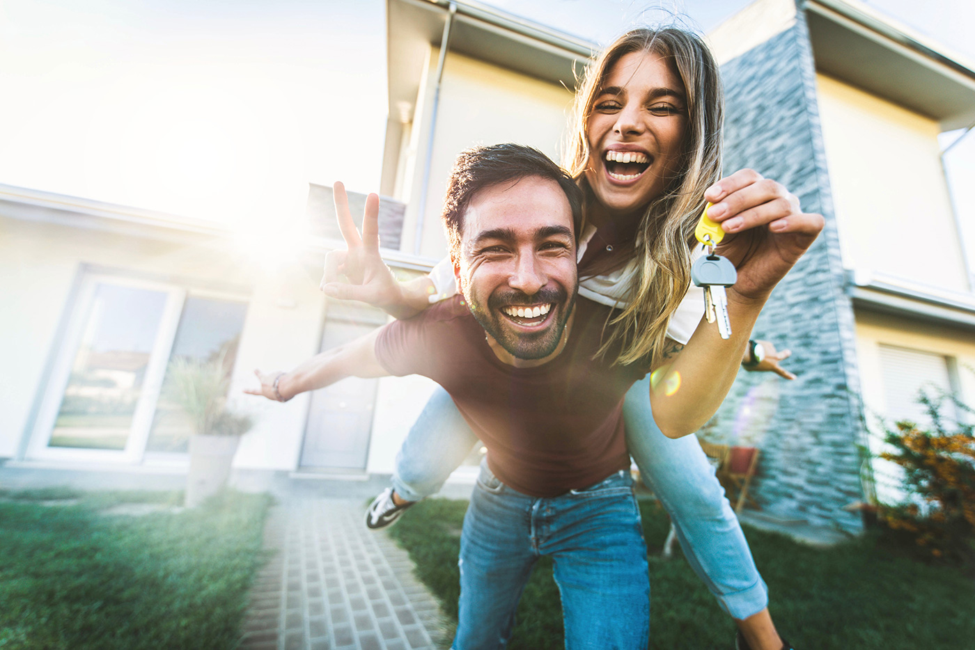 Happy-Couple-Laughing-With-Keys-in-Hand-In-Front-Of-New-Home-1400px