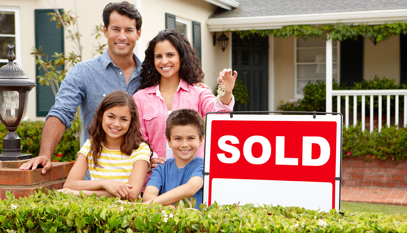 Happy Family Standing in Front of their new home with their two children