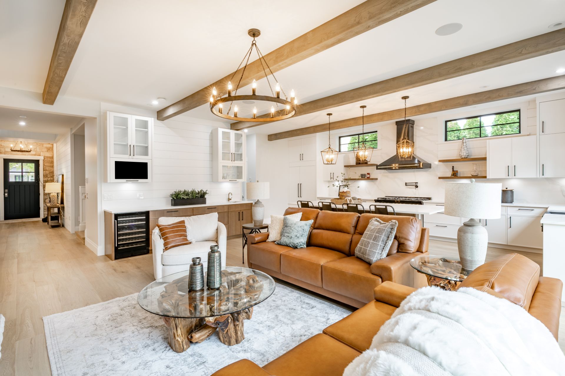 Living room interior with exposed wooden beams on the ceiling carmel colored leather sofa round wagon