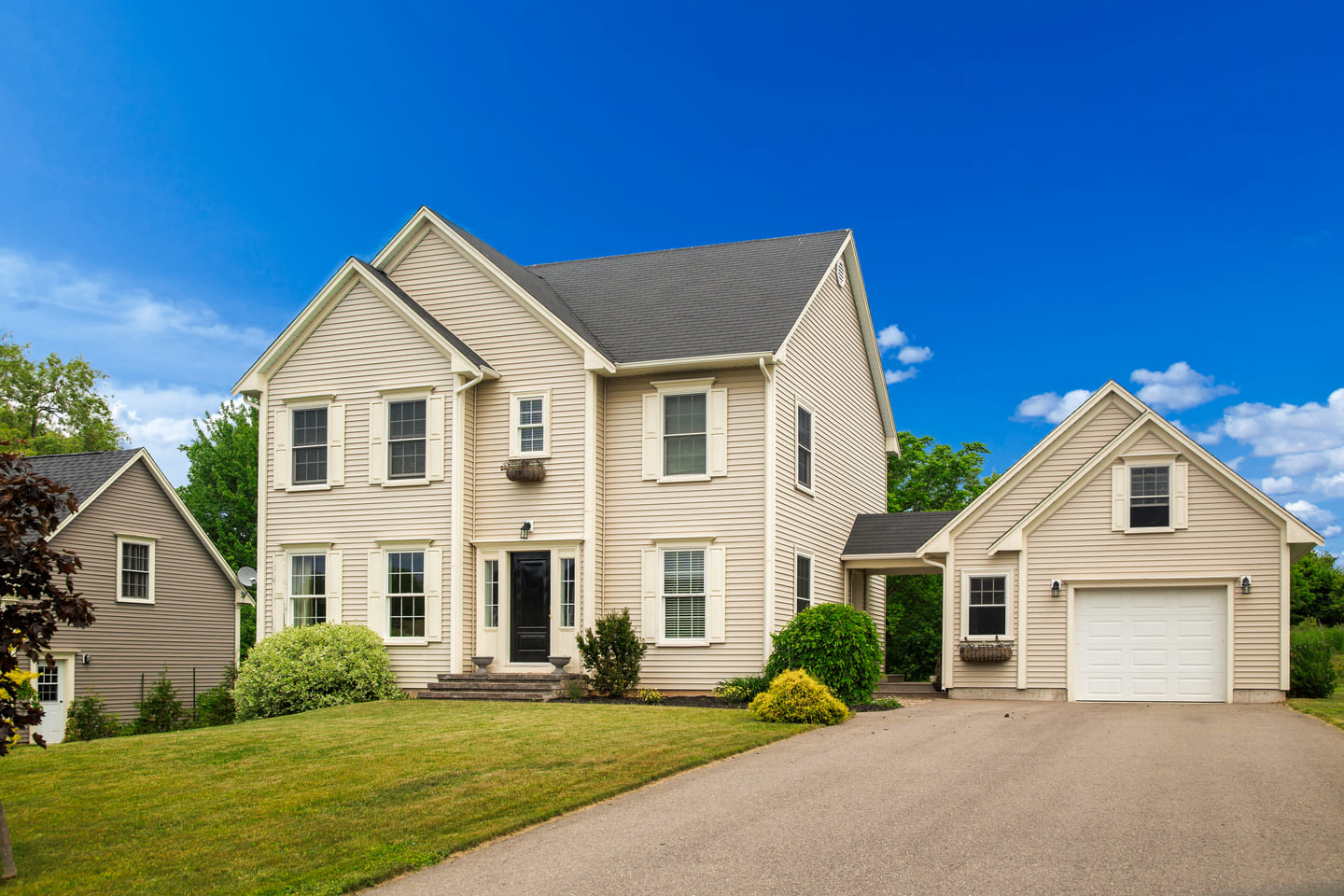 Luxury house with nicely trimmed and landscaped front yard, lawn in a North American residential neighborhood.