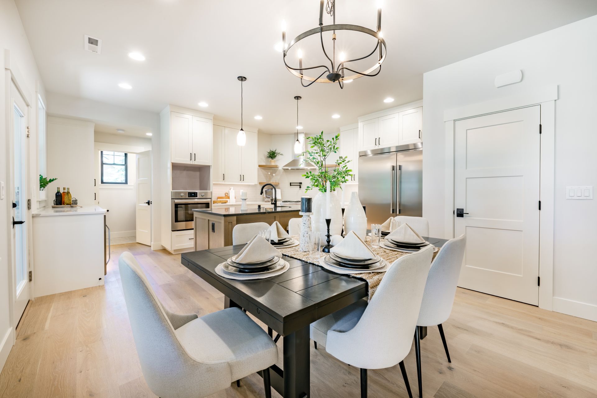 interior kitchen and dining room with high end appliances table with setting white counter and cabinets (1)