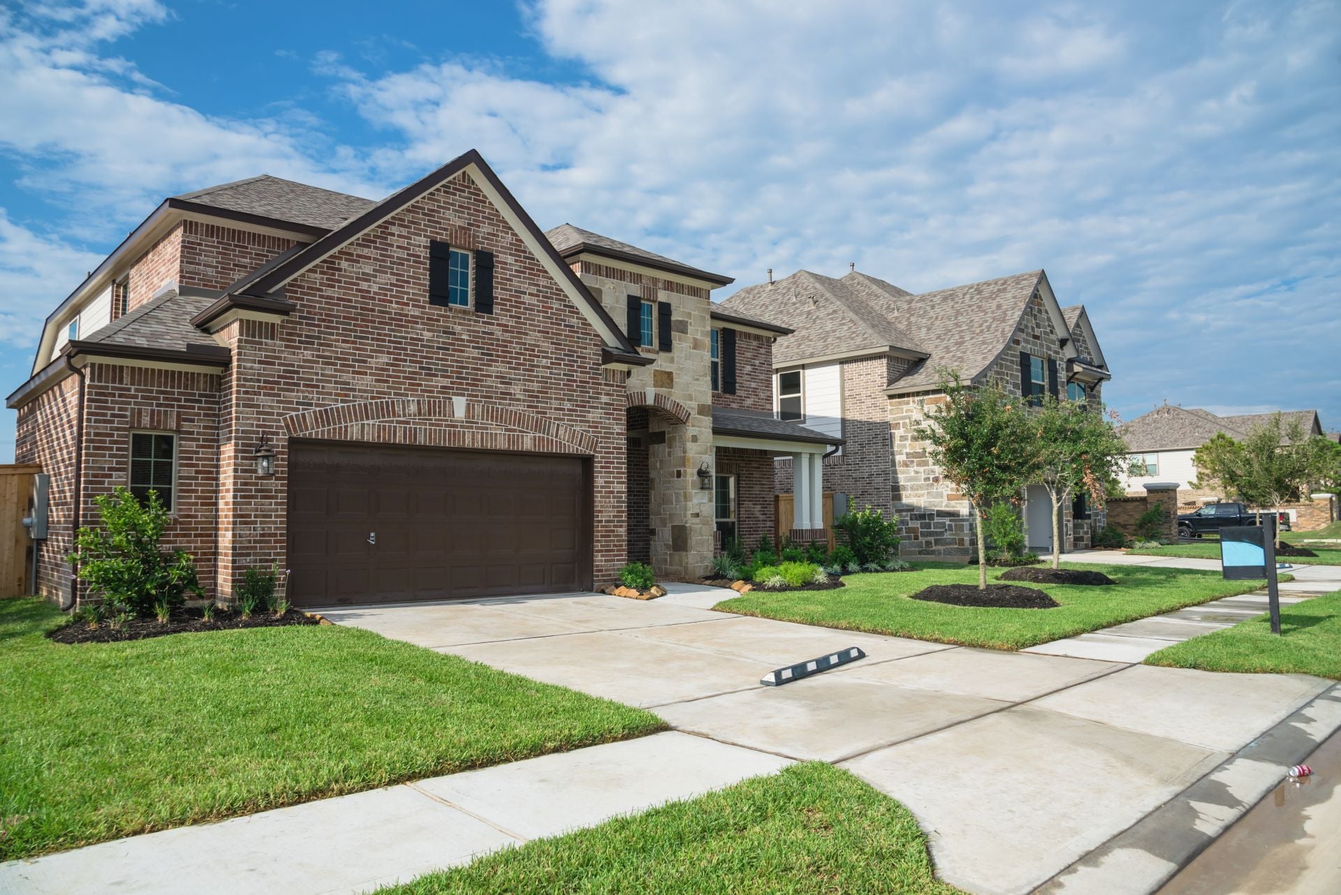 Suburban American neighborhood street with row of brand new two story residential houses in Humble, Texas, US. Newly constructed, freshly built modern home with landscaped yard.