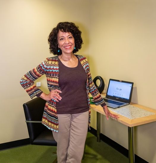 Headshot Julie Lange standing by desk