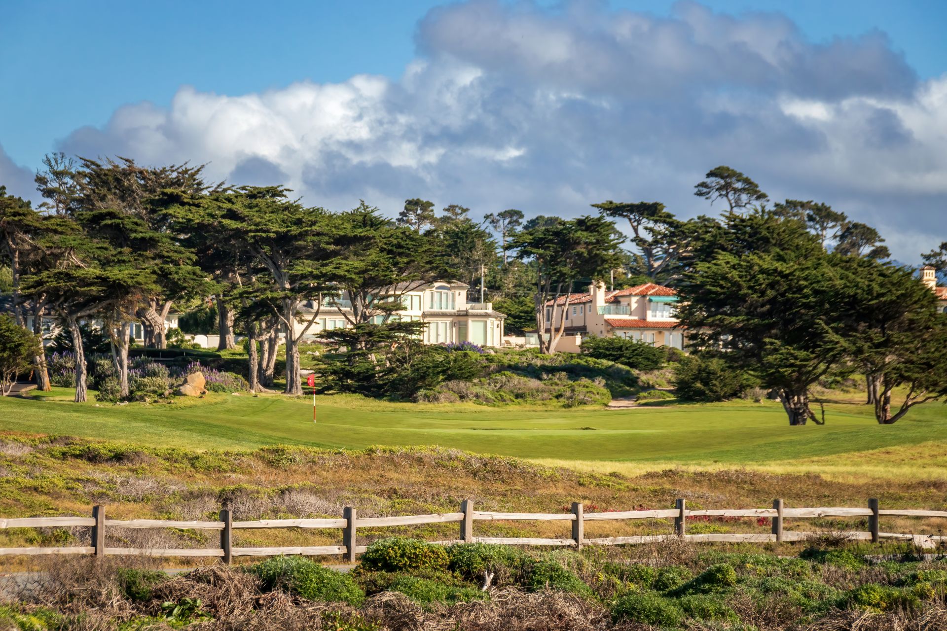 Golf Course and Houses along 17-Mile-Drive, Del Monte Forest, California, USA against blue sky with clouds