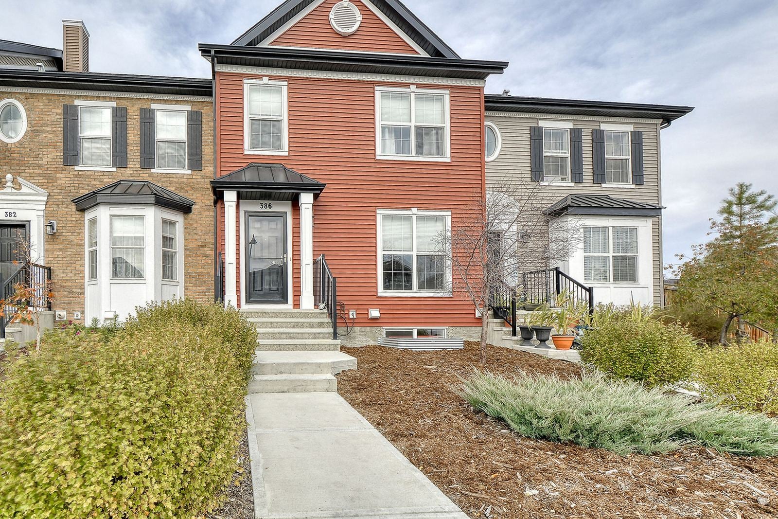 Row of townhomes with front gardens in Legacy, southeast Calgary
