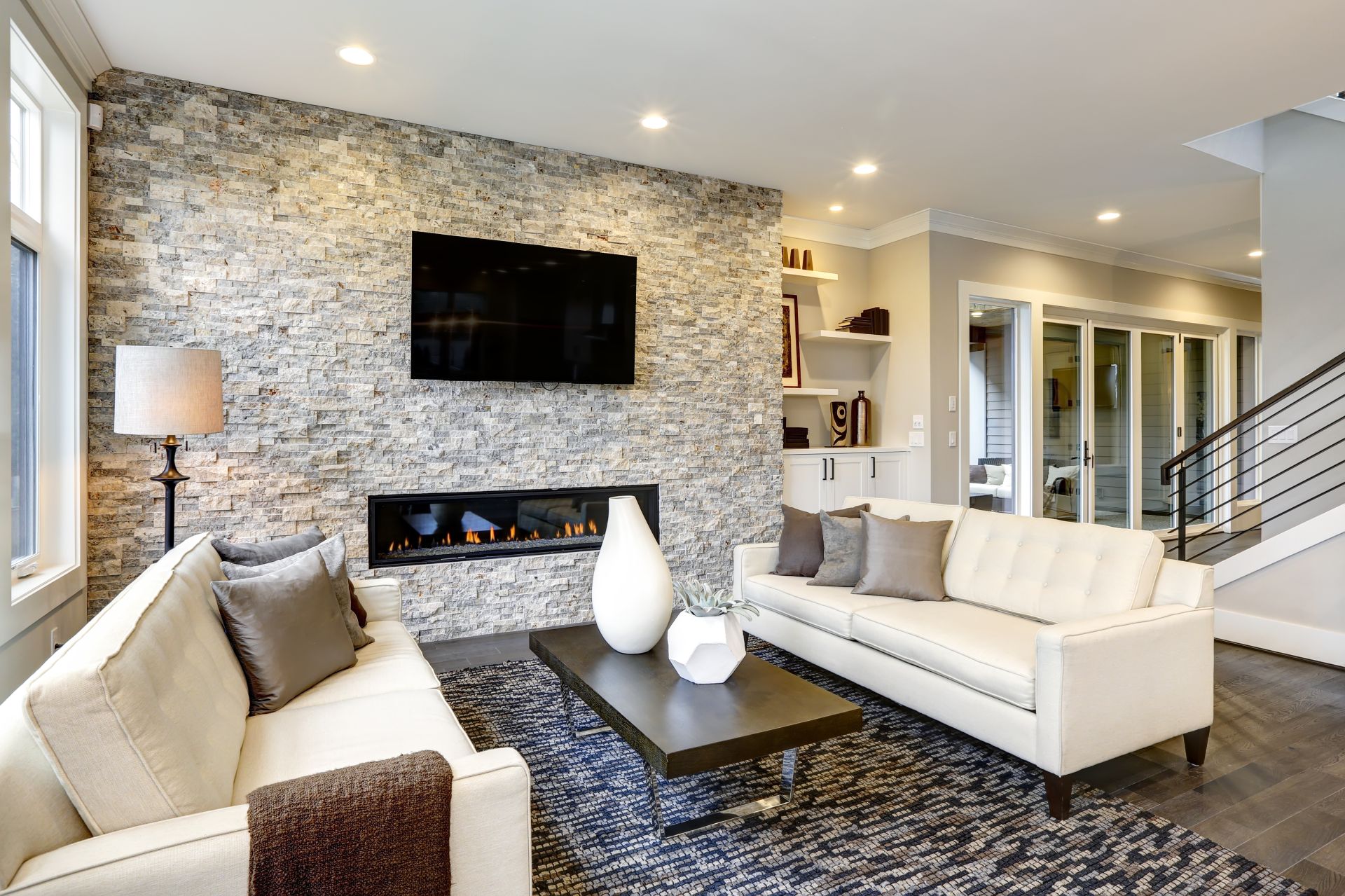 Beautiful modern living room interior with stone wall and fireplace in luxury home