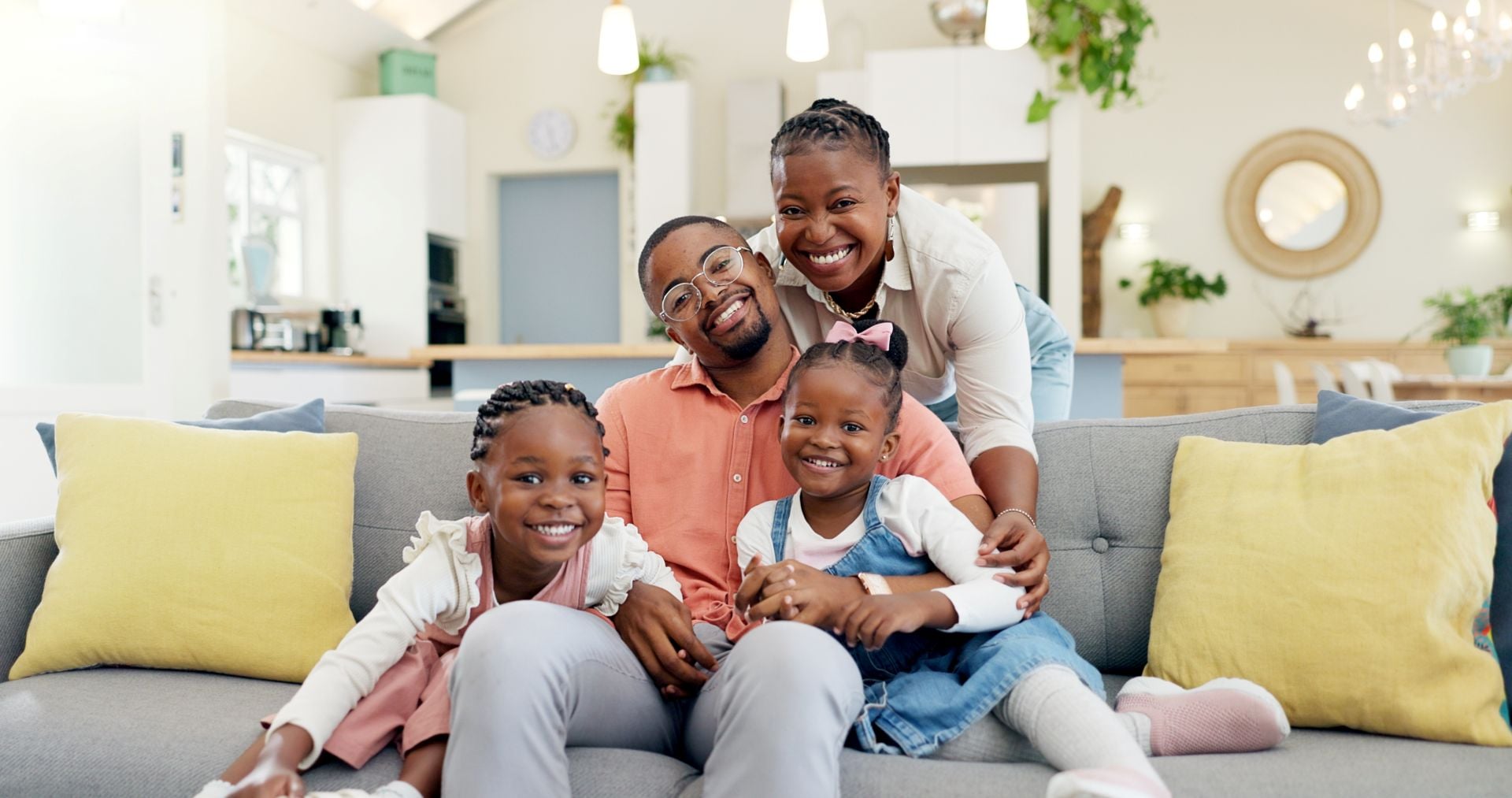 Happy, black family on sofa and in living room of their home happy together for care.