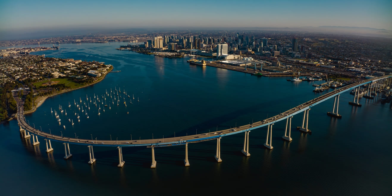 APRIL 2024, SAN DIEGO, CA. USA - sunrise view of Coronado Bridge with San Diego Skyline in view from Coronado
