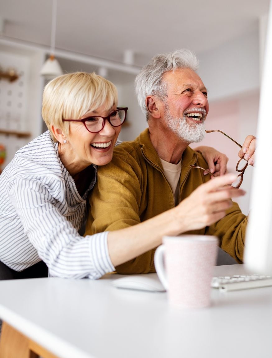 Senior woman helping senior man to use computer (2)