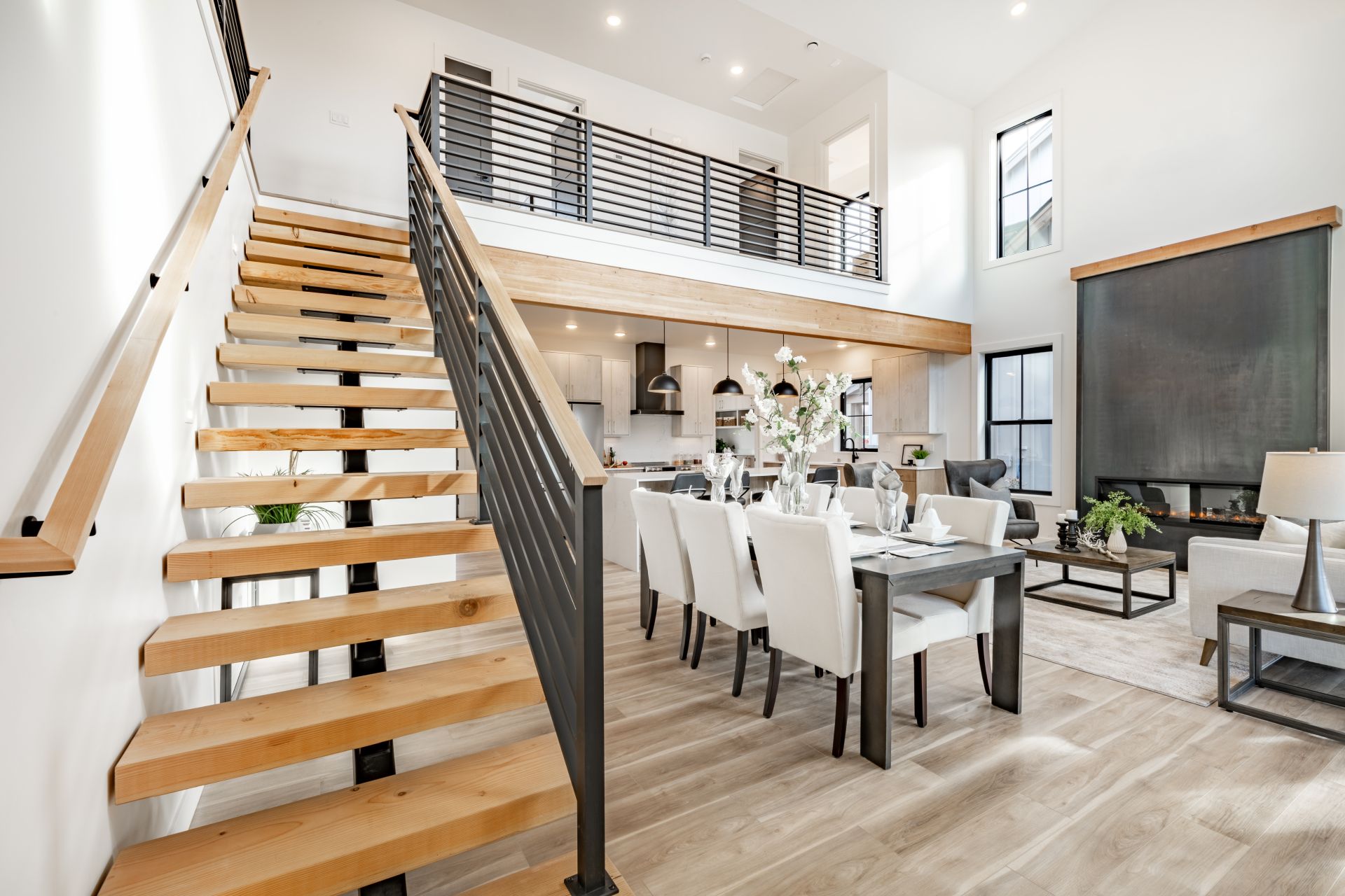 Kitchen and dining room interior with light colors of aqua blue turquoise large exposed staircase with wrought iron hardwood