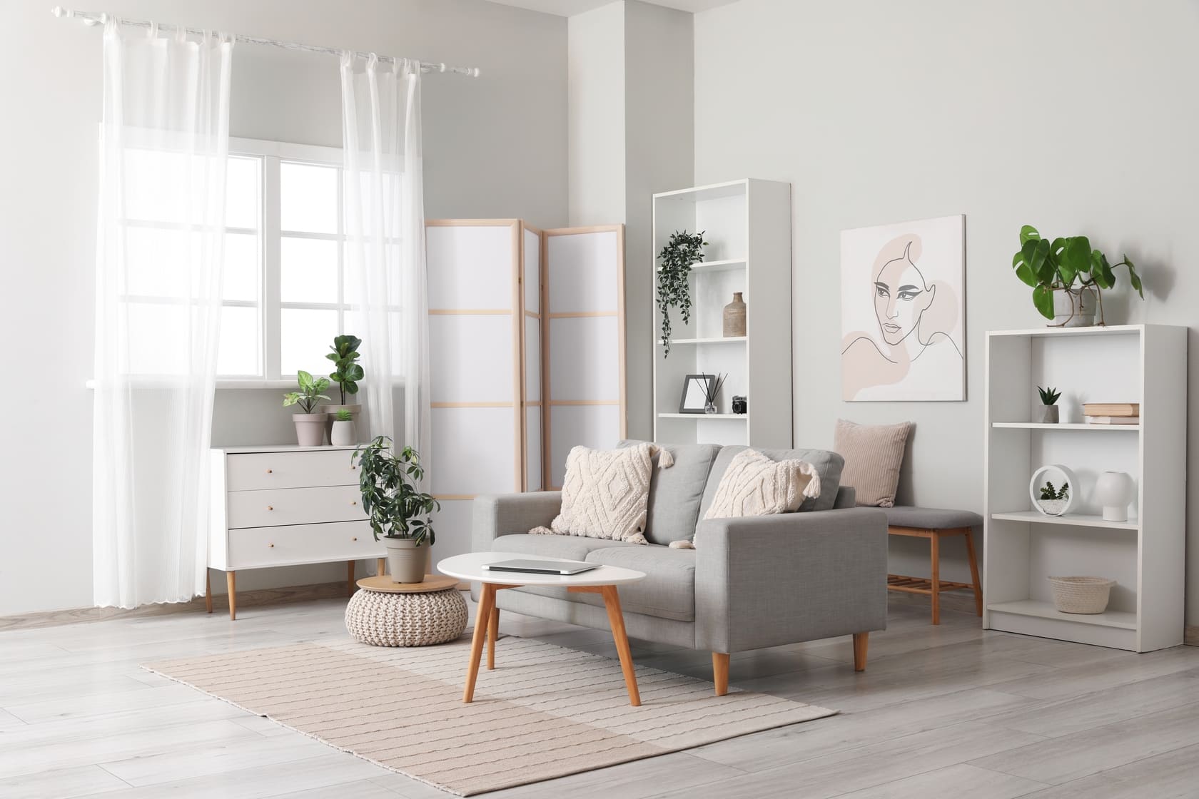 Light living room with folding screen, comfortable sofa, coffee table and chest of drawers