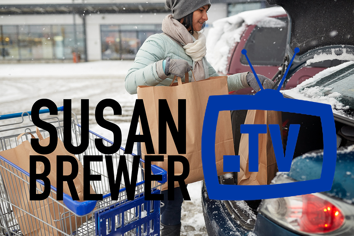 woman loading food from shopping cart to car trunk