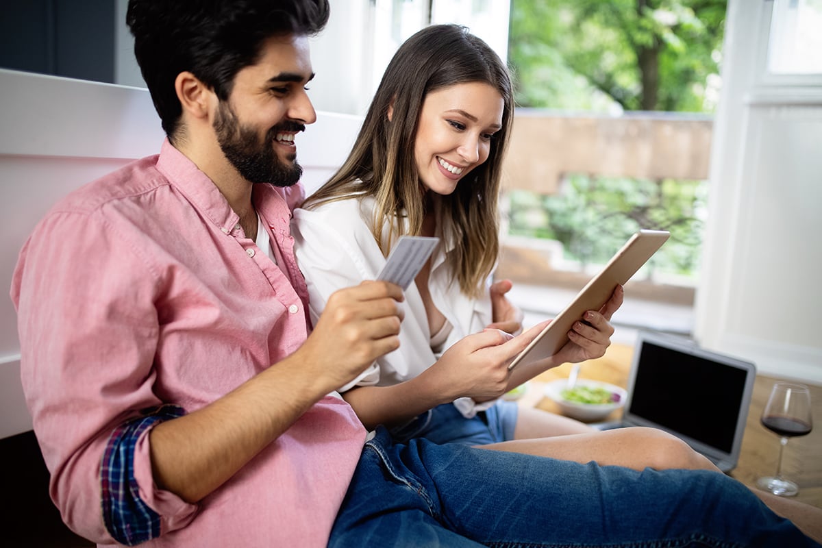 Couple with credit card buying on-line with a laptop