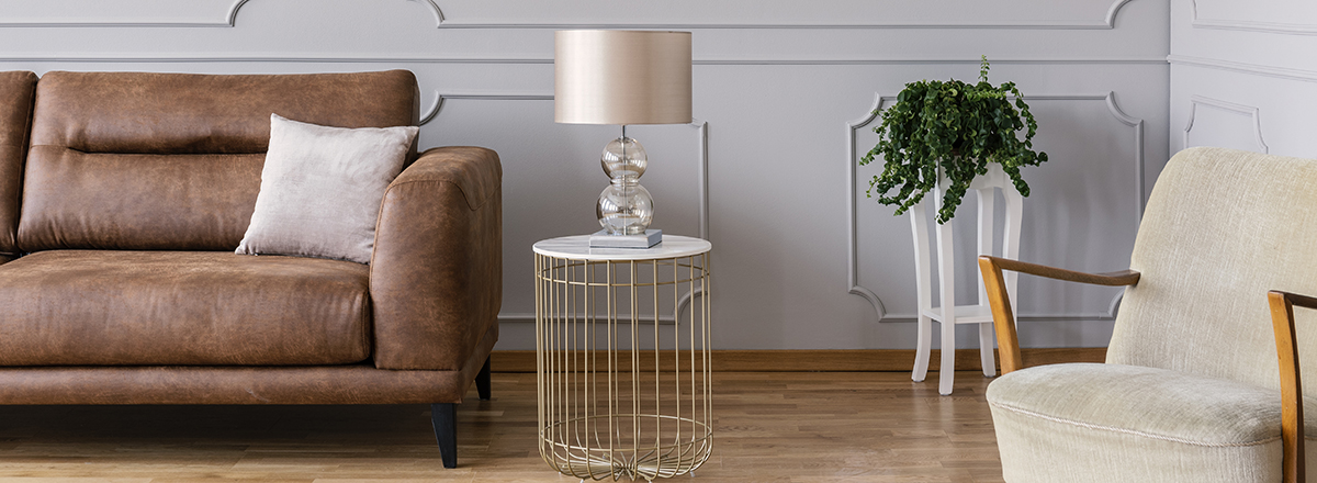 Panoramic view of vintage armchair, stylish table with lamp and