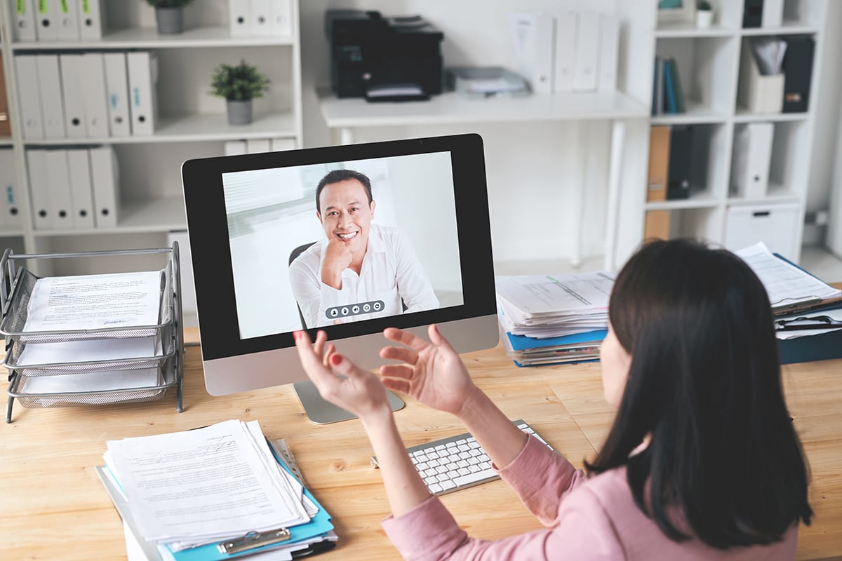 Young businesswoman looking at foreign business partner on computer screen