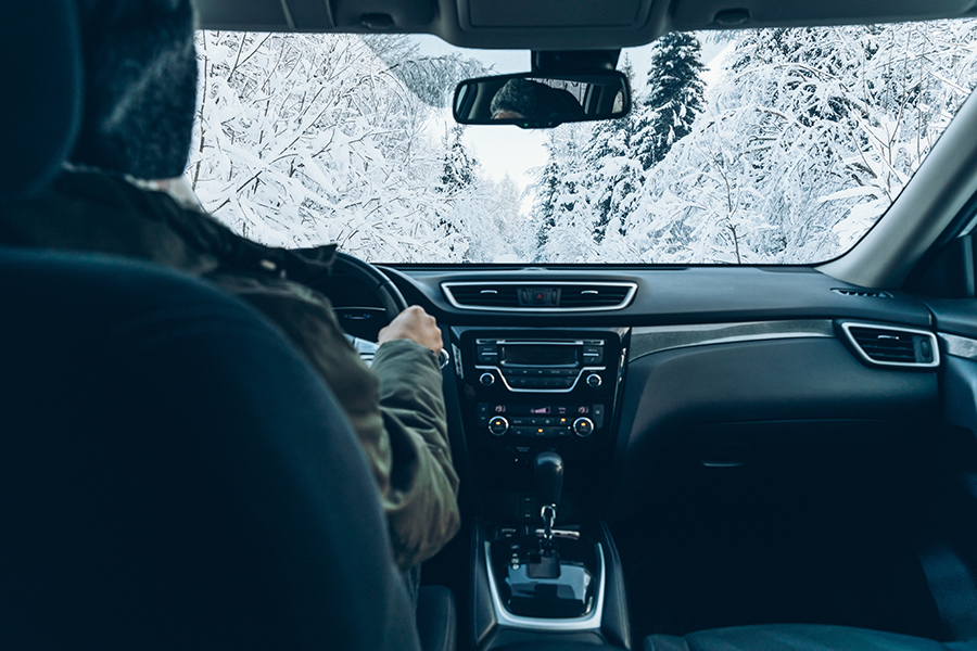 Man drives a car on snow winter road.