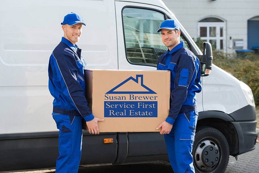 Delivery Men Carrying Cardboard Box Against Truck