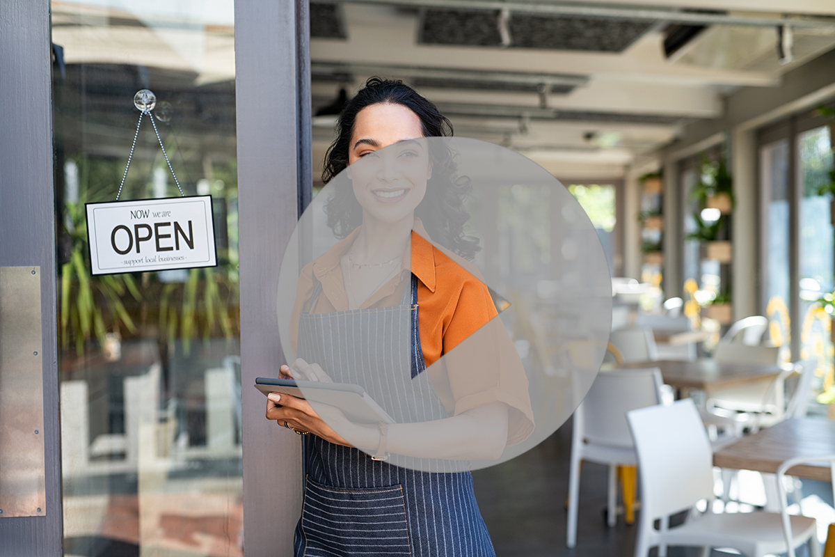 Small business entrepreneur at cafe entrance using digital table