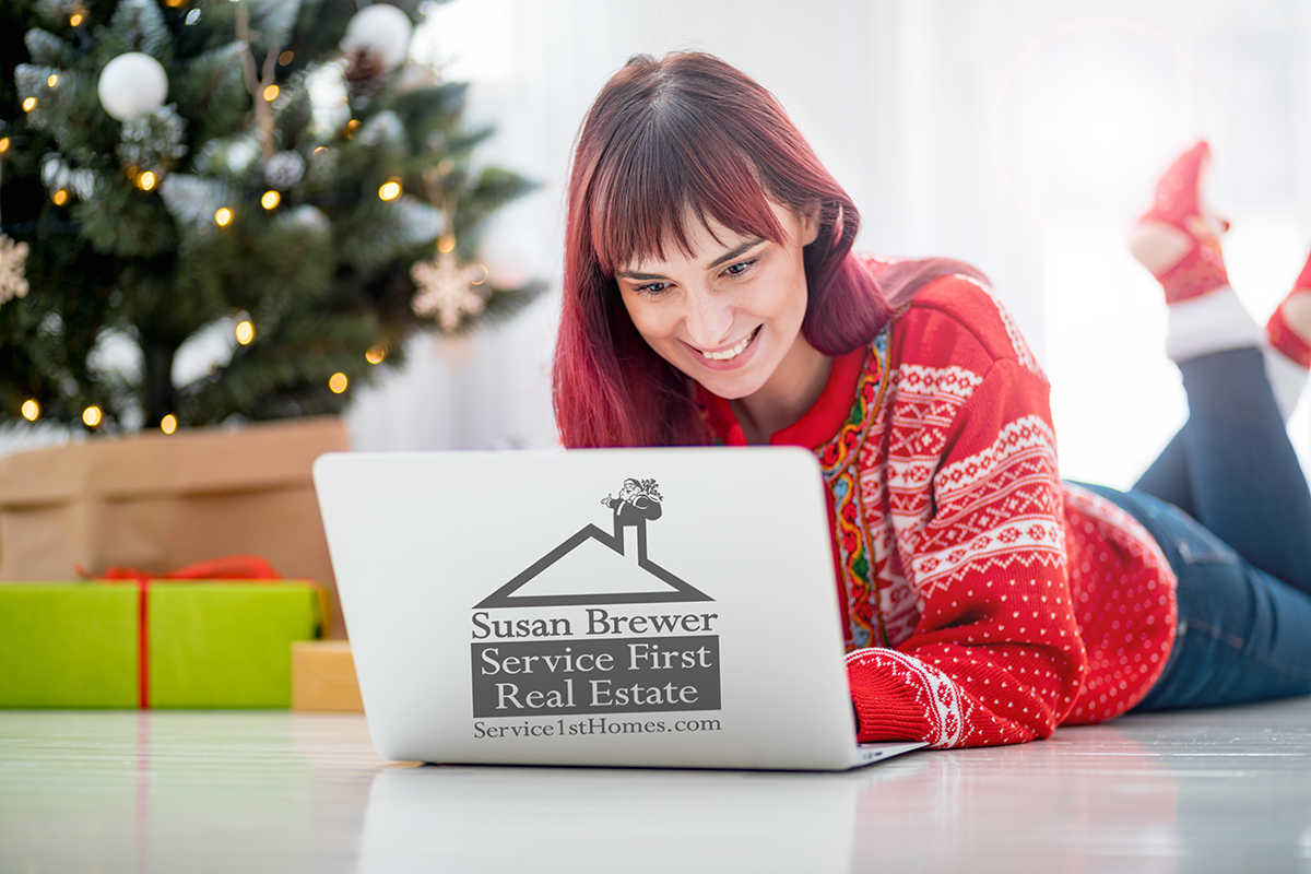 Young woman using laptop next to xmas tree, Christmas shopping o