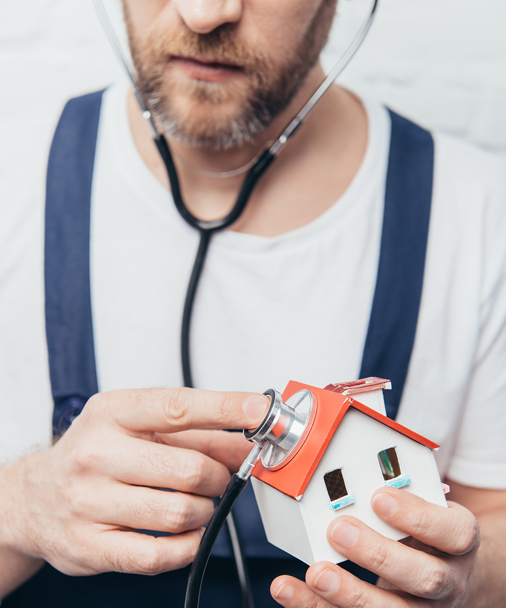 partial view of bearded male repairman checking house figure by