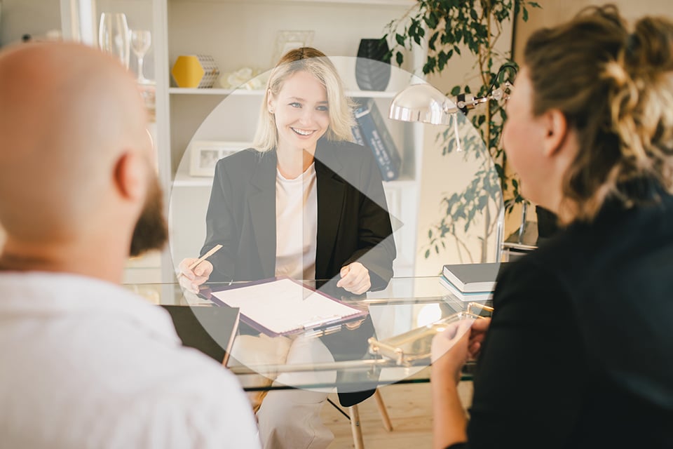 Happy couple having conversation with real estate agent in the o