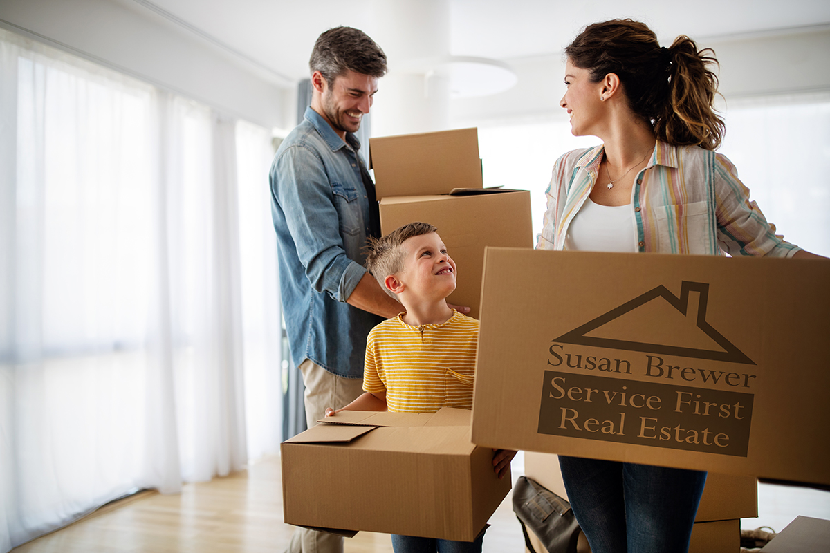 Happy family with children moving with boxes in a new apartment house.