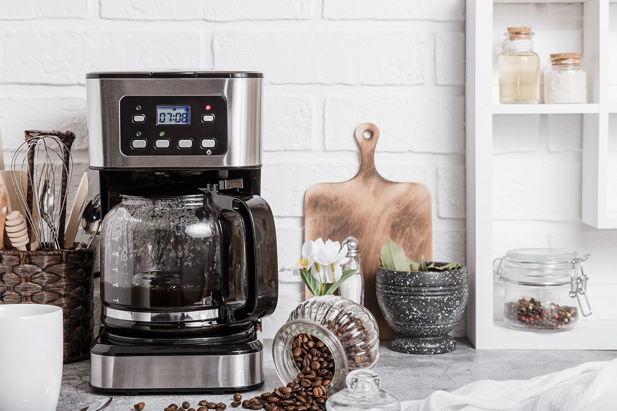 A black drip electric coffee machine with a glass teapot brews a