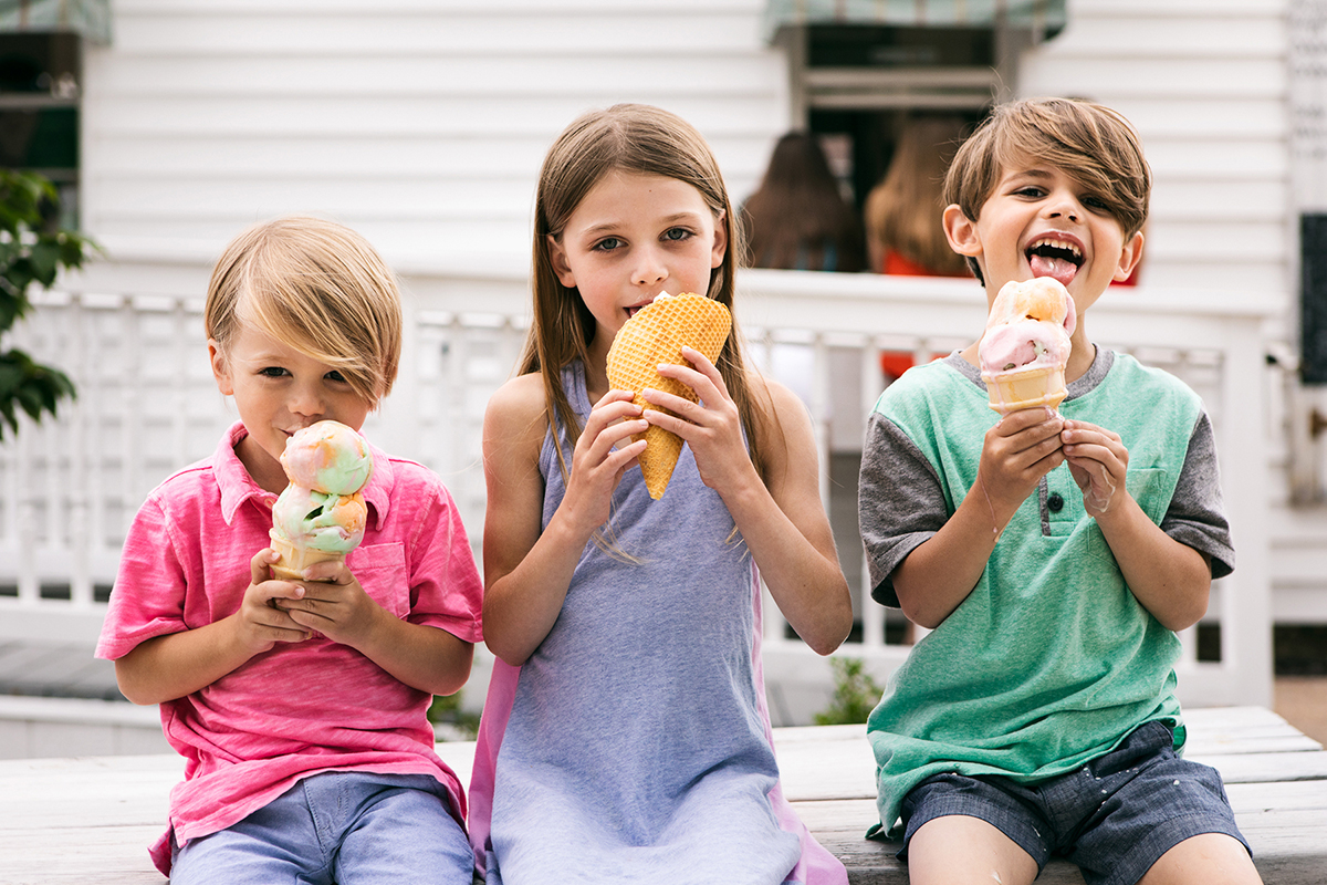 Treat: Siblings Sitting On Picnic Table Eating Ice Cream