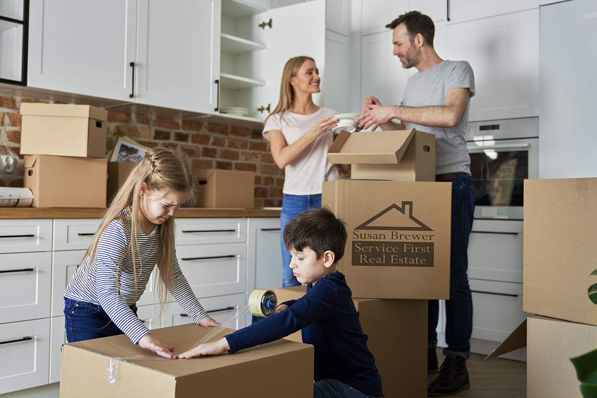 Family packing cardboard boxes for moving house