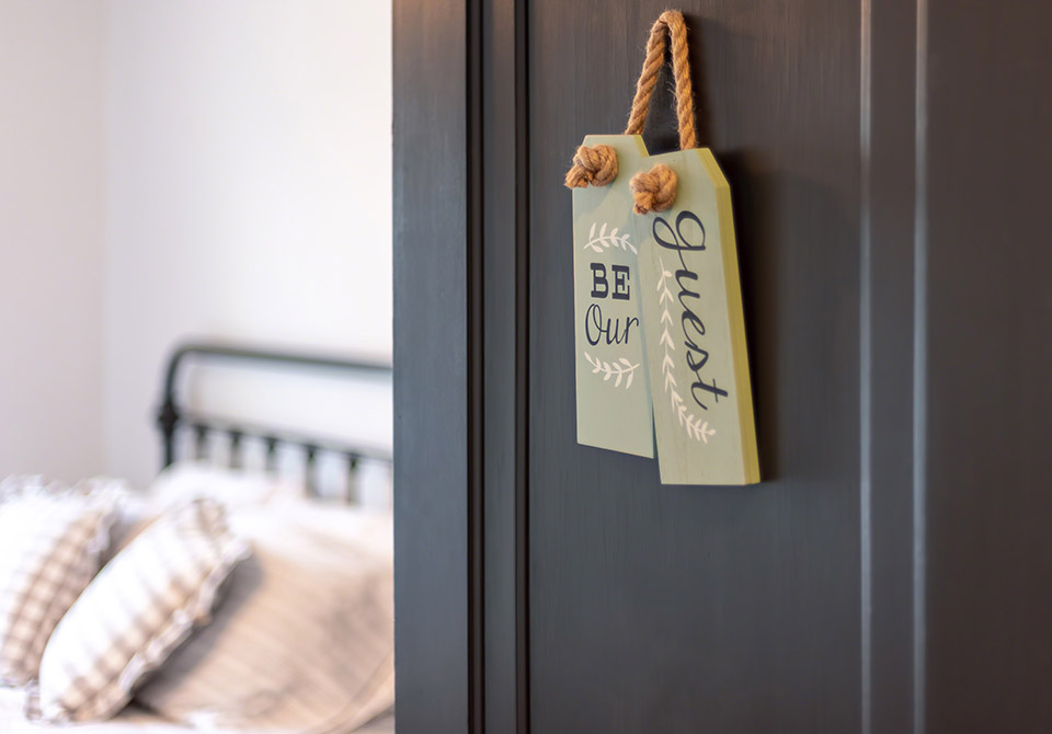 Open door with sign that says Be Our Guest (horizontal)