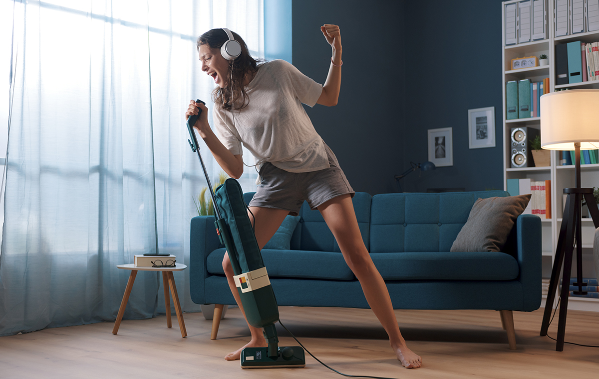 Woman cleaning up her house and singing